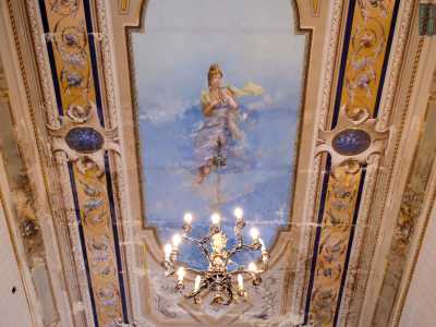 Alzando lo sguardo si resta davvero incantati. Illuminato da un lampadario a motivi vegetali contempliamo il sorprendente soffitto della stanza interamente affrescato...